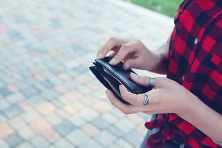 young woman holding wallet in the parkの写真素材