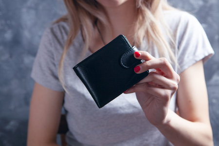 a young girl holding a wallet in her hand
