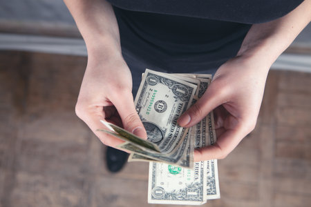 young girl counting dollar billsの写真素材