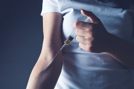the girl injects herself intravenouslyの写真素材