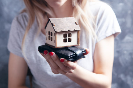 holds wallet and house in handの写真素材