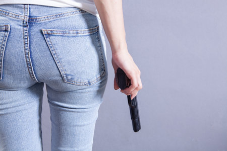 young woman holding a pistolの写真素材