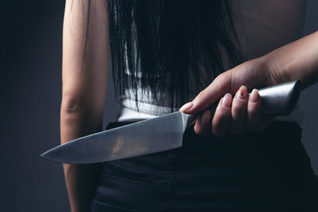 woman holding a knife from behind