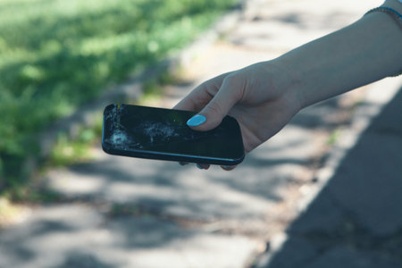 lifts a broken phone from the groundの写真素材