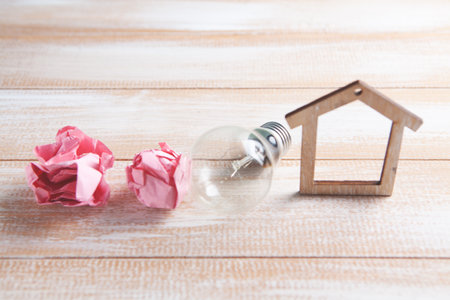 house, crumpled paper and a light bulb on the tableの写真素材