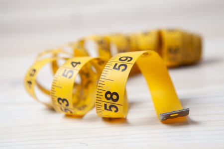 measuring tape in the form of a spiral on the tableの写真素材