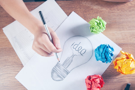 woman draws a light bulb with the inscription idea
