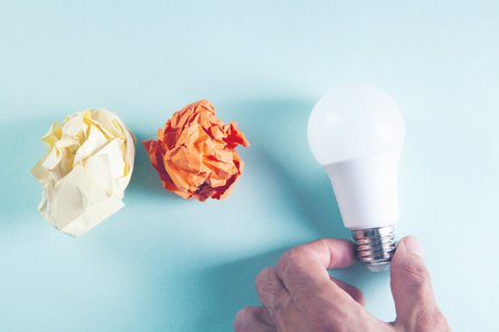 crumpled papers and a light bulb on the tableの写真素材