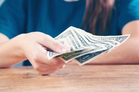 young woman holding dollar billsの写真素材