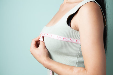 young girl measures her breastsの写真素材