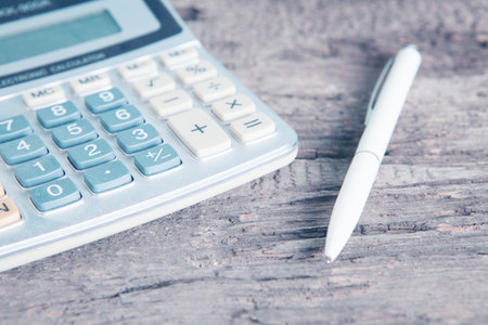 a pen and a calculator on the tableの写真素材