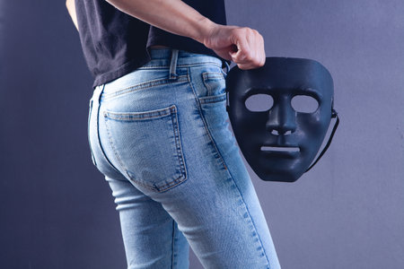 young girl holding anonymous maskの写真素材