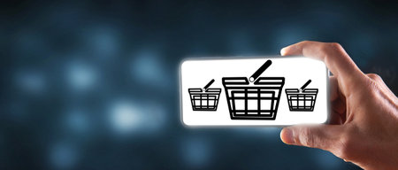 holds the phone with shopping baskets. online shoppingの写真素材