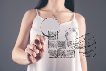 magnifying glass looks at a painted staircase made of wooden cubes and a light bulbの写真素材