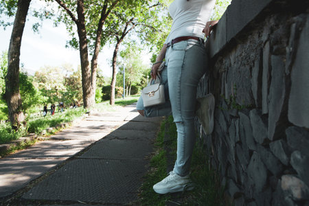 young girl walks in the park with a handbag