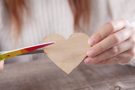 woman cuts a heart with scissors