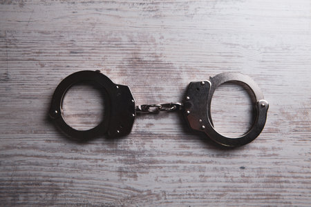 handcuffs on a wooden tableの写真素材