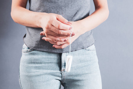 young woman holding a tampon and hand near the vaginaの写真素材