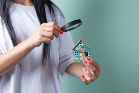 woman looking at the house with a magnifying glassの写真素材