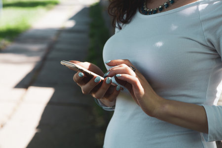 woman holding phone in the parkの写真素材