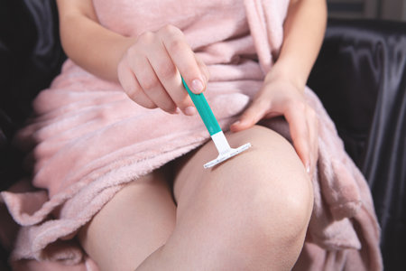 young woman shaves her legsの写真素材
