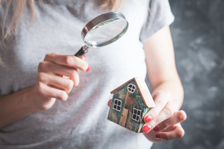 woman looking at the house with a magnifying glassの写真素材