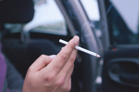 a man sits in a car and smokesの写真素材