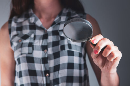 young woman holding a magnifying glassの写真素材