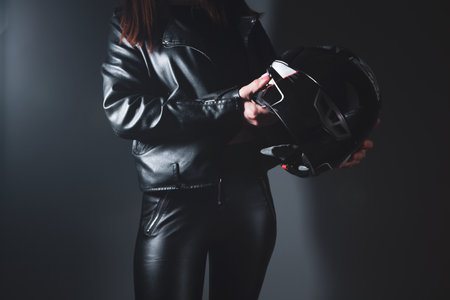 woman stands holding helmet from motorcycleの写真素材