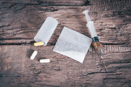 white powder, capsules and syringe on the tableの写真素材