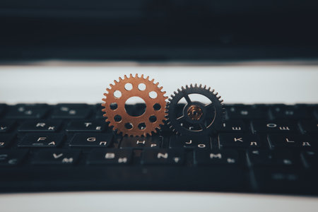 Metal gear wheels on a computer keyboard.の写真素材