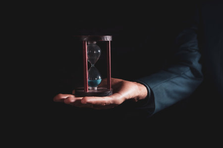 man holding an hourglass in his handの写真素材