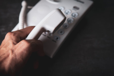 hand holding a home phone receiver