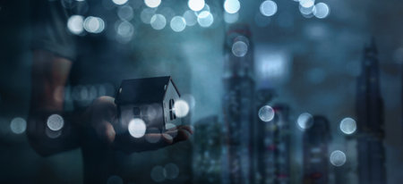 Real estate agent holding house model on blurred background. 3D renderingの写真素材