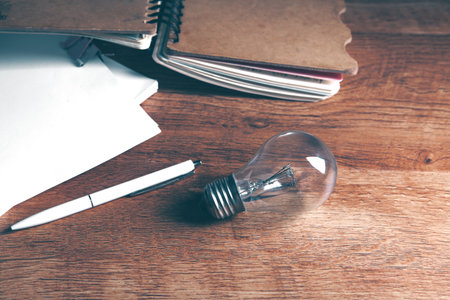 light bulb, crumpled papers and notepad on the tableの写真素材