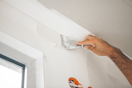 Plastering wall with putty-knife, close up image.の写真素材