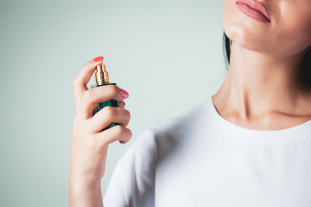 woman sprinkles perfume on her neckの写真素材