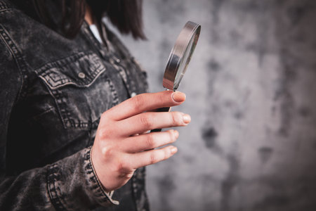 Woman holding a magnifying glass in her hand. close up.
