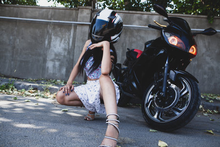 woman in black dress sitting on a motorcycle