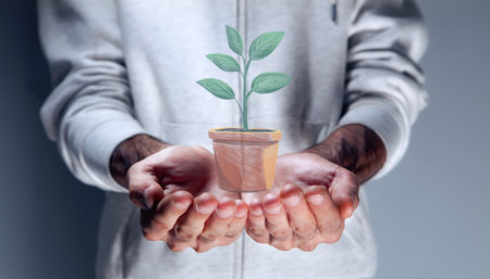 close up of young man holding glass with green plant