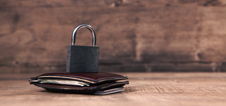 wallet with padlock on wooden table