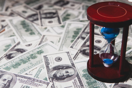 dollars and hourglass on the table
