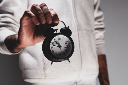 close - up of a man holding a alarm clock
