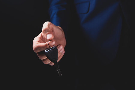 businessman in suit holding keys in his hands