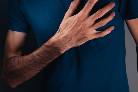 close up of man holding chest with pain, heart attack concept