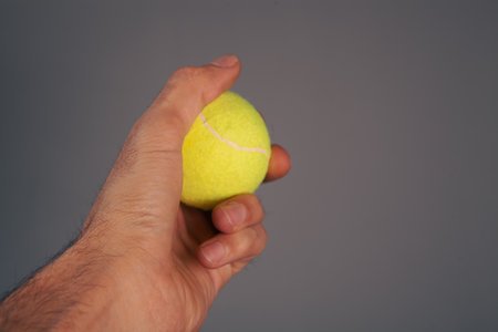 man hand holding tennis ball