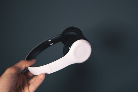 hand holding a white wireless headphones