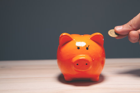 piggy bank with coin on wooden table. saving conceptの写真素材
