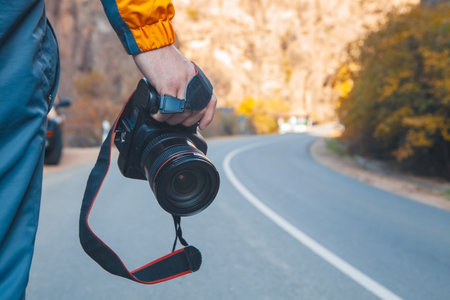 photographer taking photo with camera on the mountain backgroundの写真素材