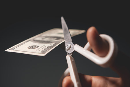 scissors cutting dollar banknote on grey background.の写真素材